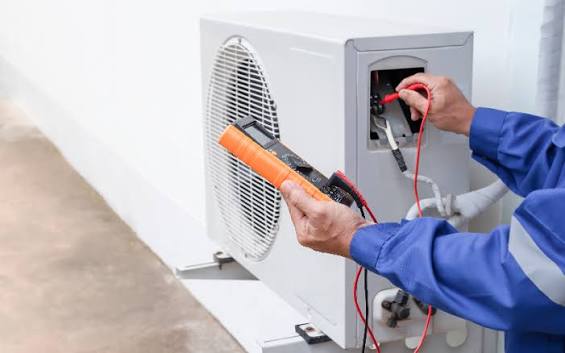 Technicien contrôlant l'unité extérieure d'une pompe à chaleur lors d'un entretien au Cannet-des-Maures